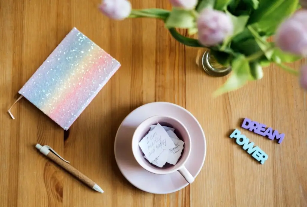 photos d'un petit carnet coloré et d'une tasse avec des petits mots dedans