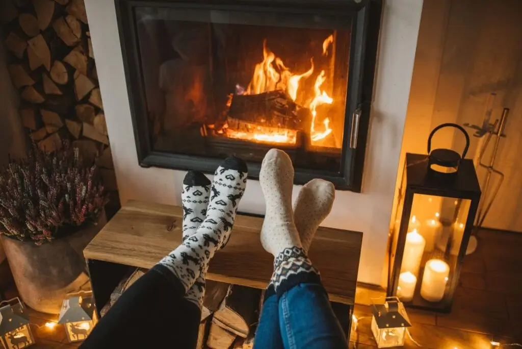 photo d'un feu de cheminée avec 2 pieds posés devant