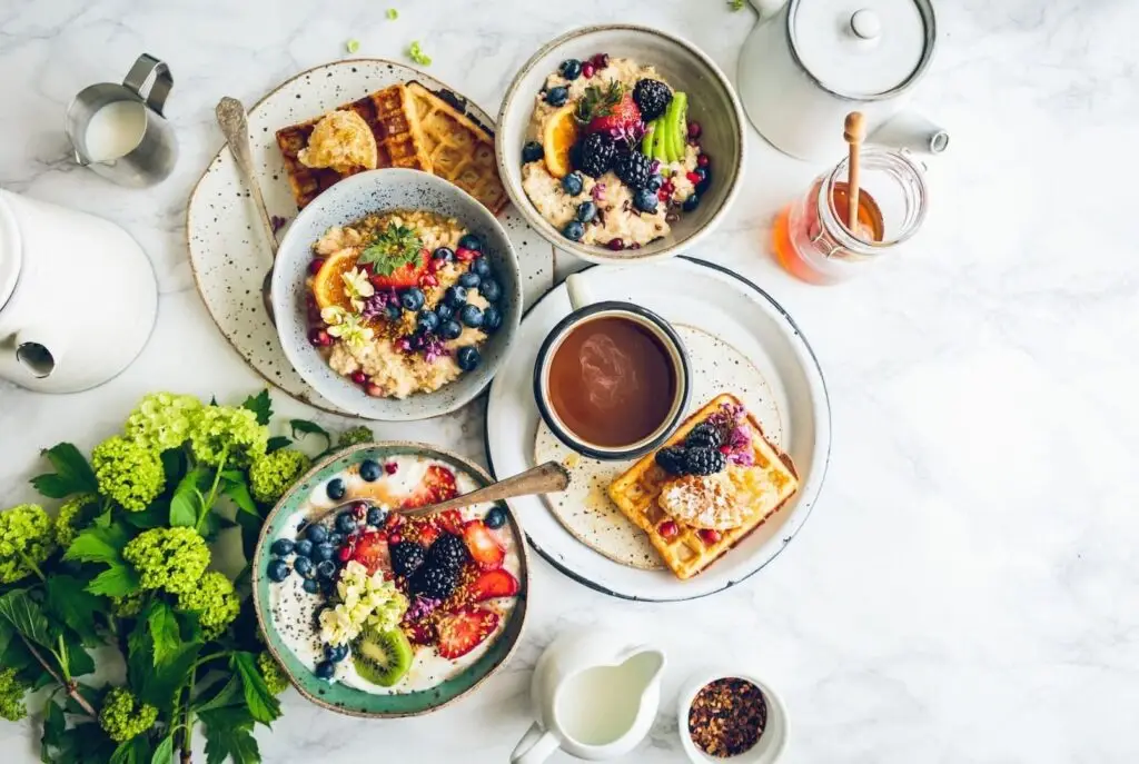 Photo d'une table de petit déjeuner avec 3 bols de céréales et fruits frais