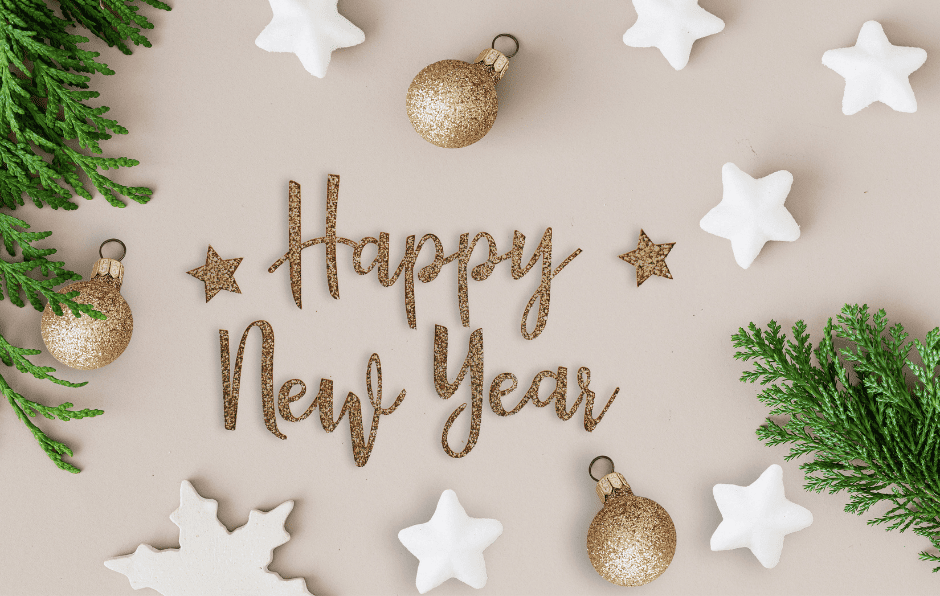 image sur fond crème avec des boules de Noël doré et des étoiles au centre, il est écrit HAPPY NEW YEAR