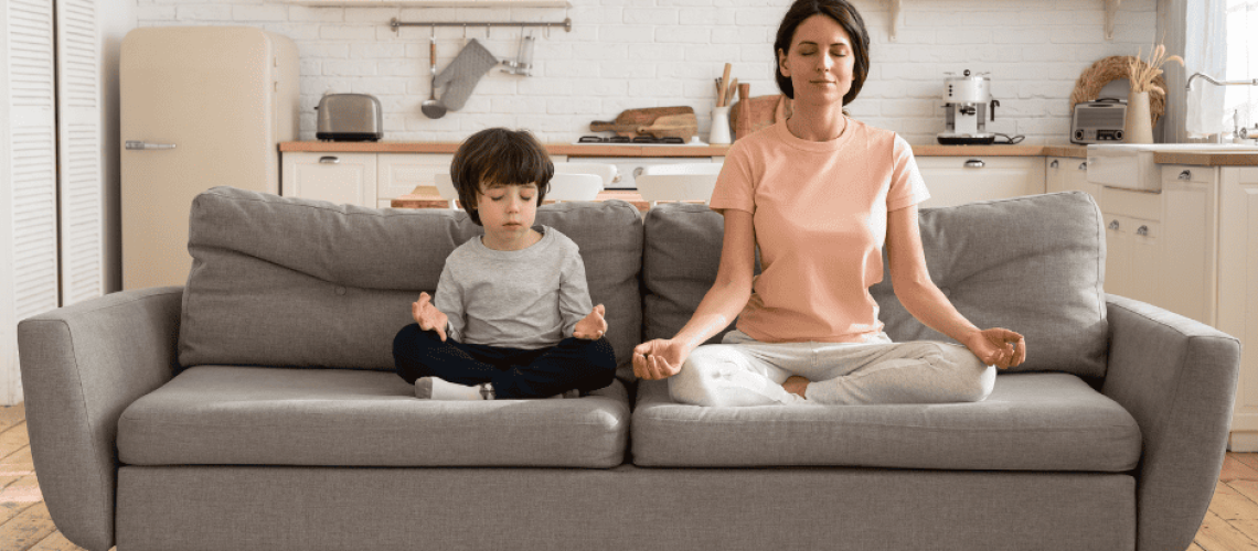 sophrologie-naturopathie-maman-zen photo d'une maman et son fils en position de yogi sur un canapé gris