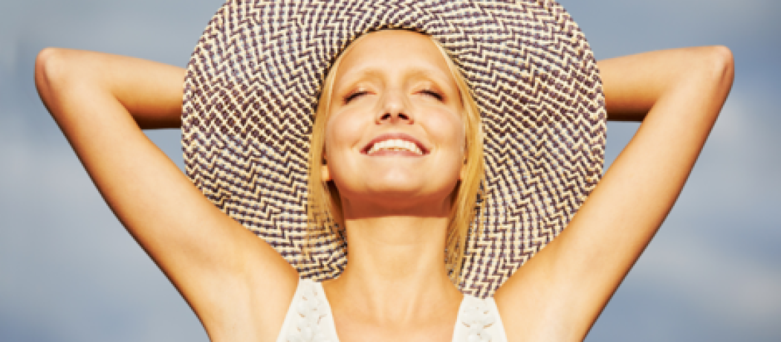 sophrologie-naturopathie-femme-chapeau Photo d'une femme souriant les bras derriĂšre son chapeau de paille