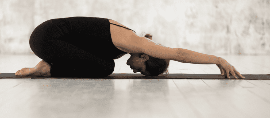 sophrologie-naturopathie-auto-massage Photo d'une femme au sol le buste posé sur ses cuisses, la tête au sol et les bras tendu devant elle pour s'étirer